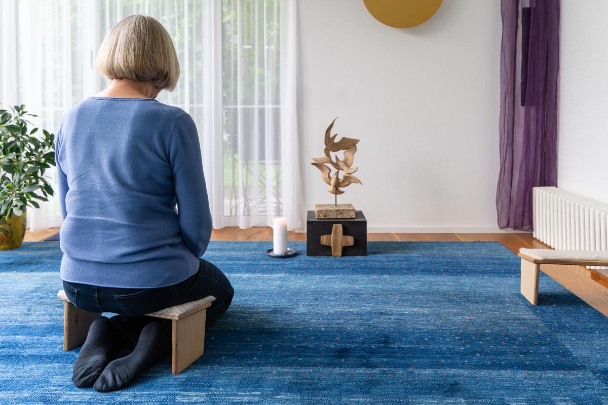 Eine Frau kniet im Raum der Stille