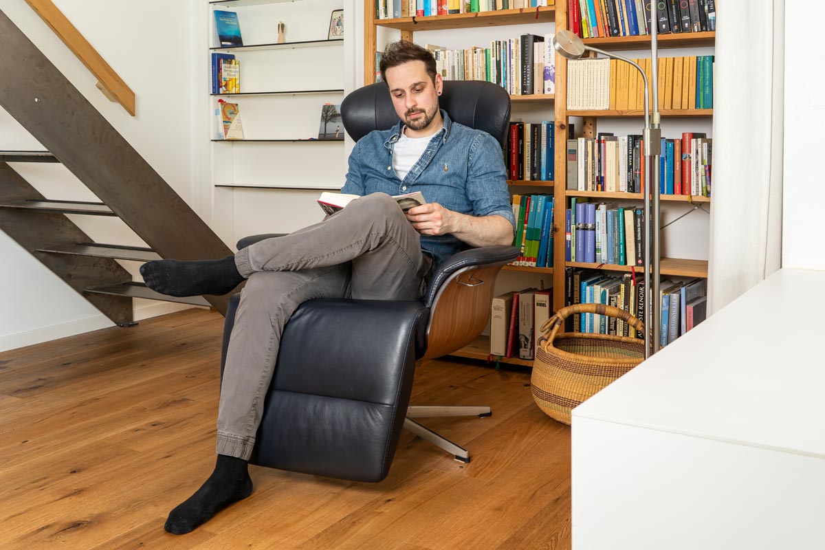 Ein lesender Mann in einem Sessel